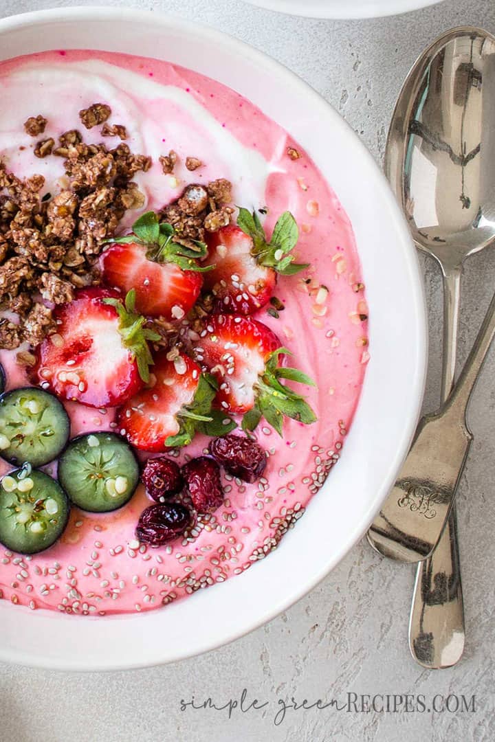 Over head shot of the Strawberry Banana Smoothie Bowl topped with fresh fruit, granola and dried cranberries.