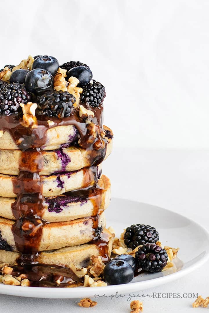 Eye-level shot of the Vegan Blueberry Oat Pancakes, loaded with blueberries and super moist. 