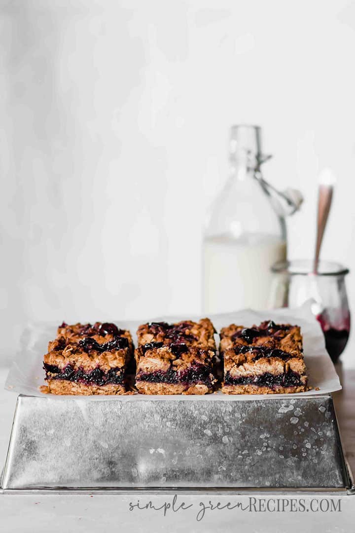+Eye-level shot of the vegan Healthy Blueberry Oatmeal Bars placed on a silver baking tray.