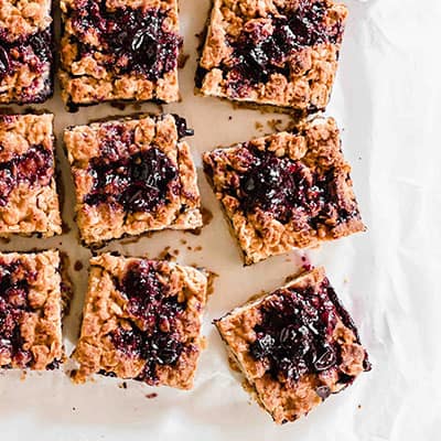 Close up of the Vegan Blueberry Oatmeal Bars sliced sliced and topped with blueberry compote.