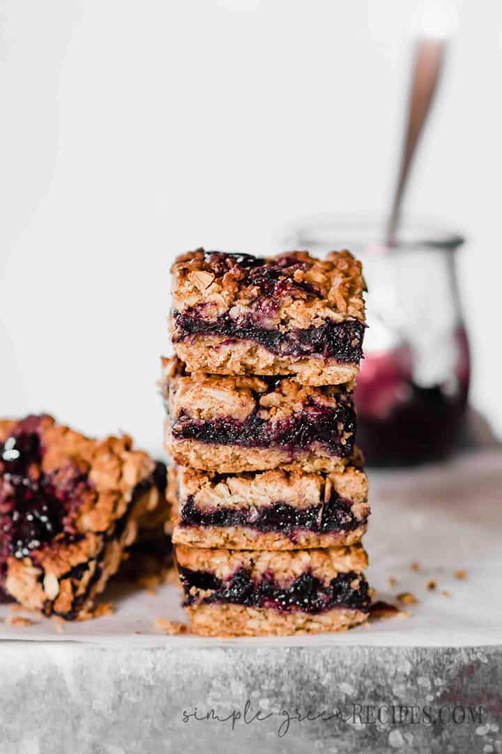+ Eye-level shot of the stack of Blueberry Oatmeal Bars filled with blueberry jam.