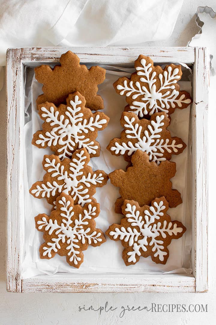 Over head shot of the decorated star shaped cookies in a wooden tray.