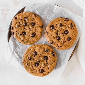 three chocolate chip cookies on a parchment paper