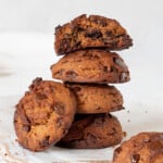 stack of peanut butter cookies with chocolate chips, on a white wooden cutting board