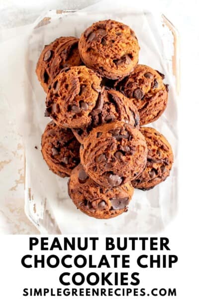 pile of peanut butter cookies with chocolate chips, on a white wooden cutting board