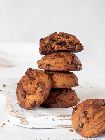 stack of peanut butter cookies with chocolate chips, on a white wooden cutting board