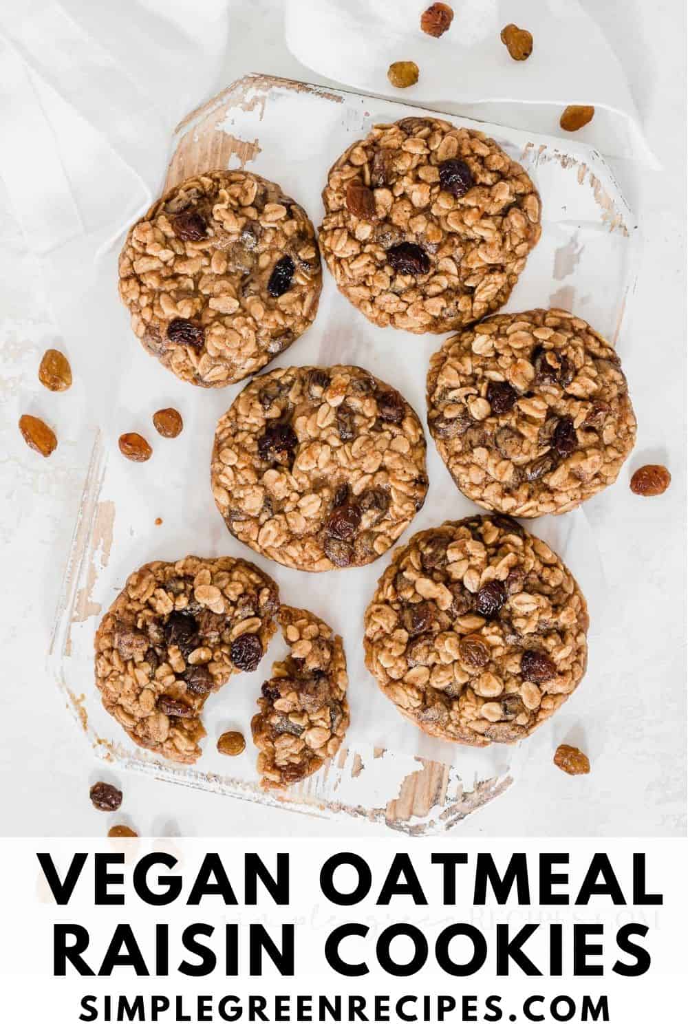 split vegan oatmeal cookie on a white board, surrounded by more cookies