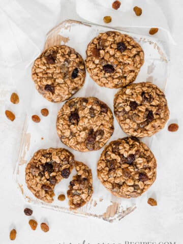 split vegan oatmeal cookie on a white board, surrounded by more cookies