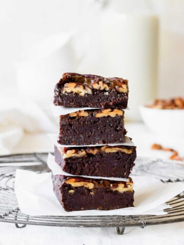 Stack chocolate brownie pecan bars on a cooling rack