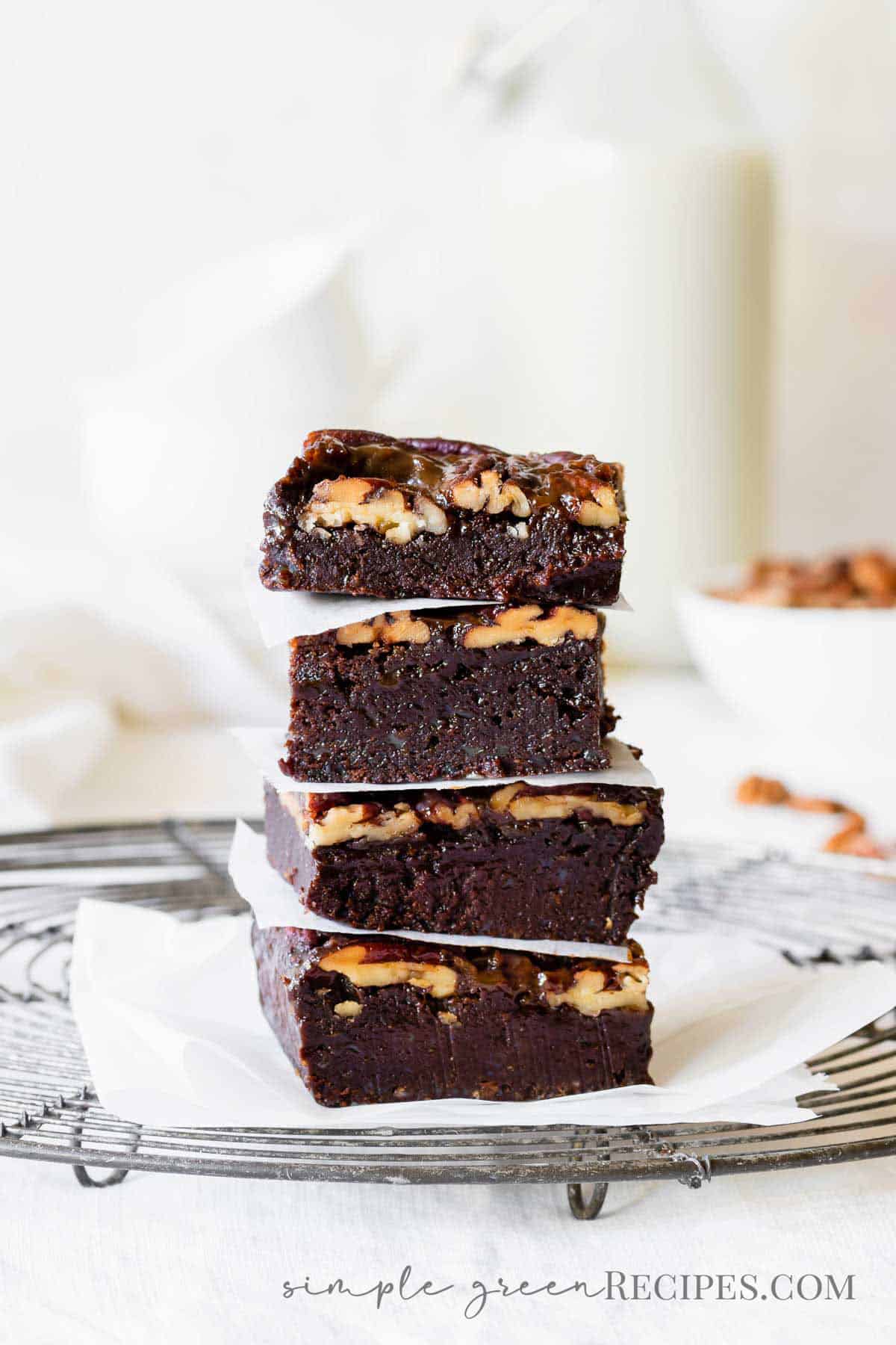 Stack chocolate brownie pecan bars on a cooling rack